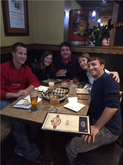 A family sitting at a restaurant table celebrating a birthday.